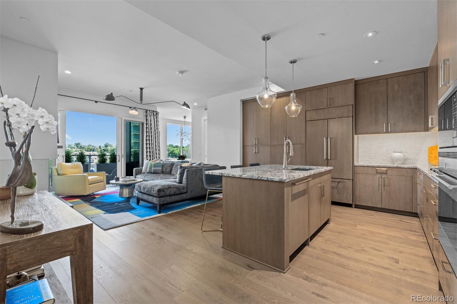 a kitchen with kitchen island granite countertop a sink counter and chairs