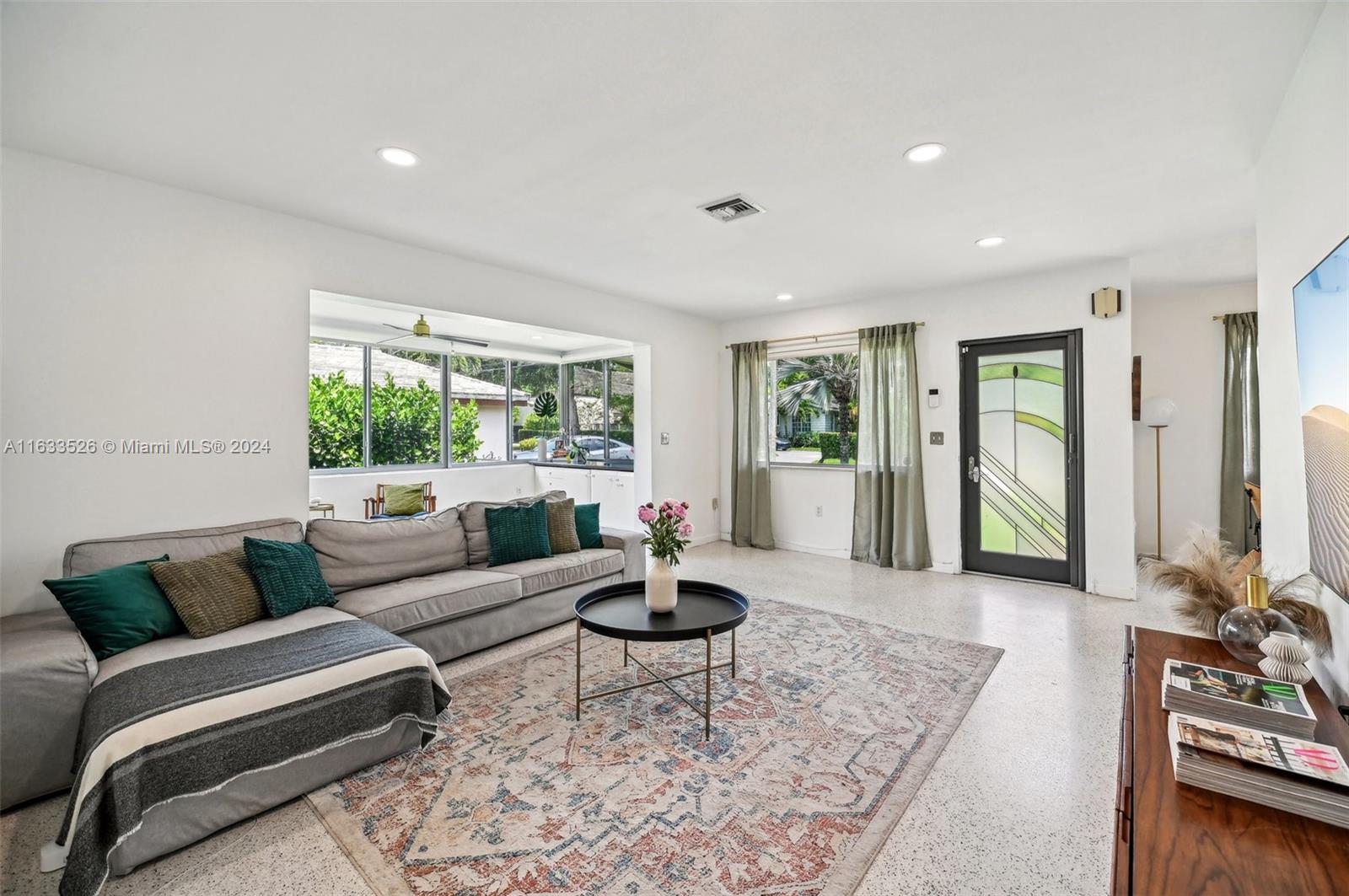 a living room with furniture and floor to ceiling windows