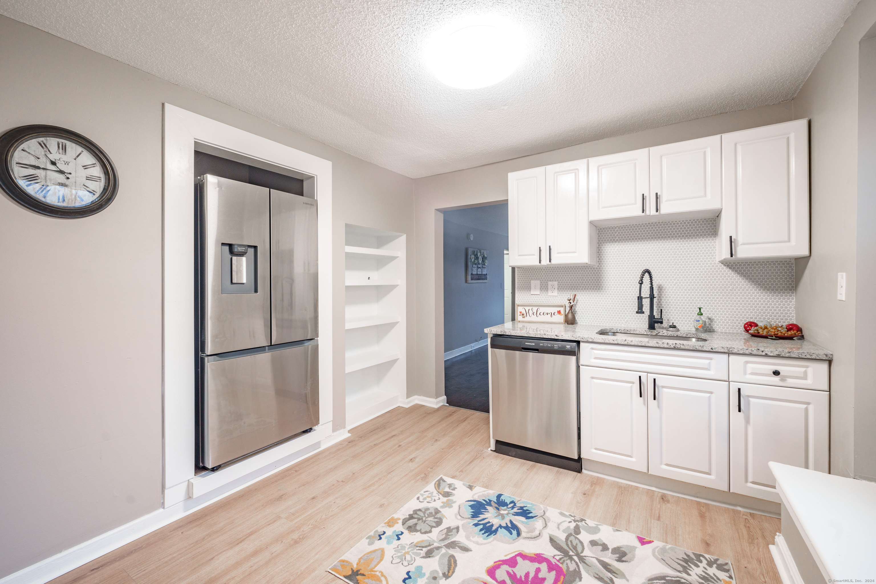 a kitchen with a sink a refrigerator and cabinets