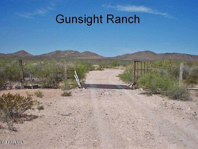 a view of a dirt road with a building in the background