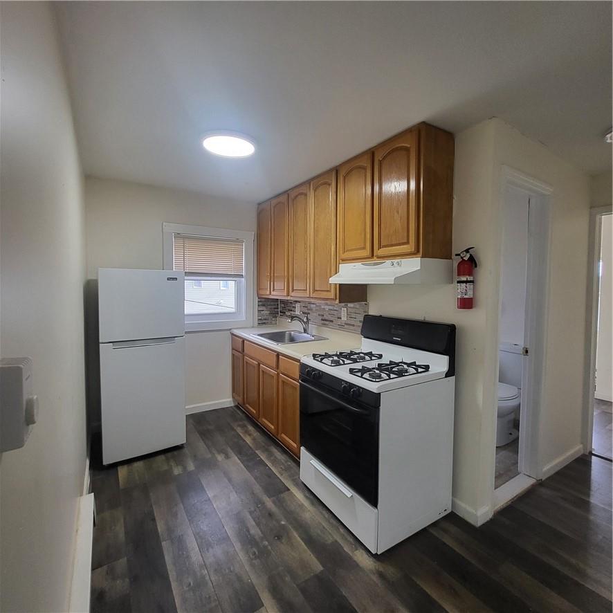 a kitchen with a stove a refrigerator and a sink