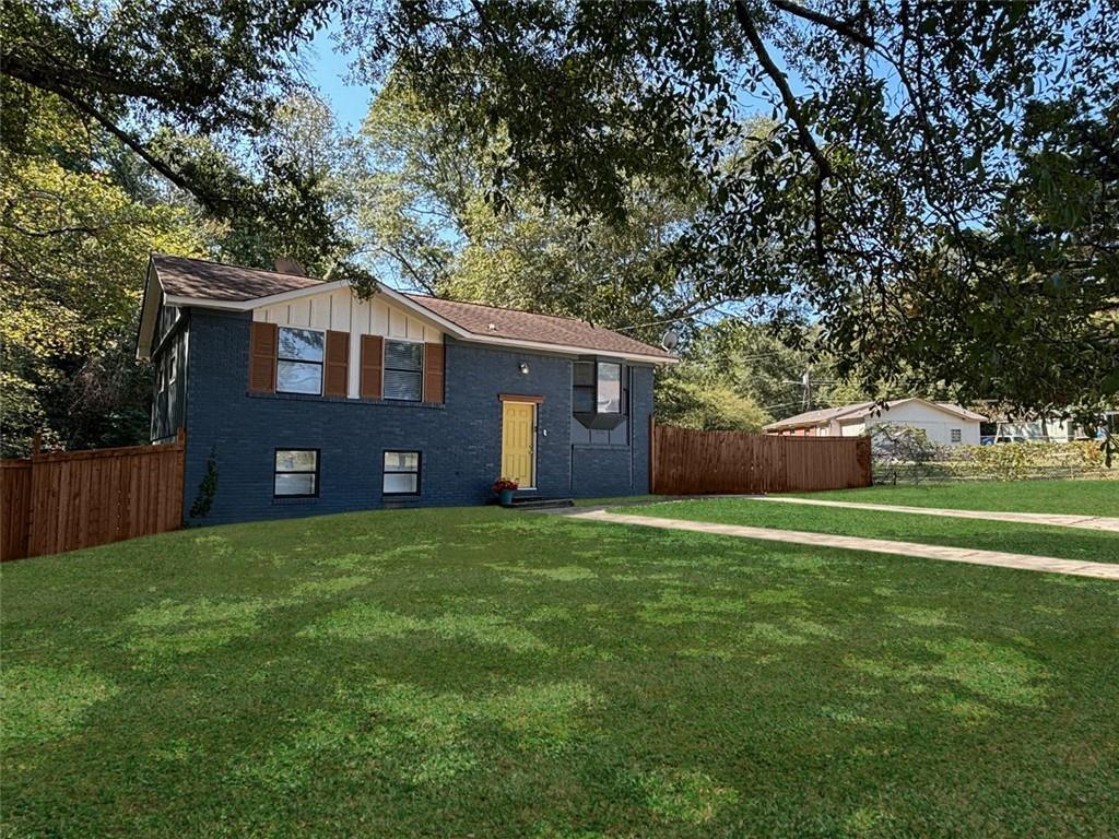 a front view of house with yard and trees all around