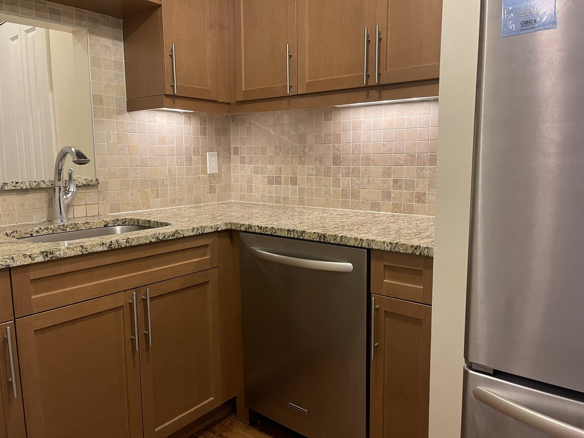 a kitchen with granite countertop cabinets stainless steel appliances and a sink