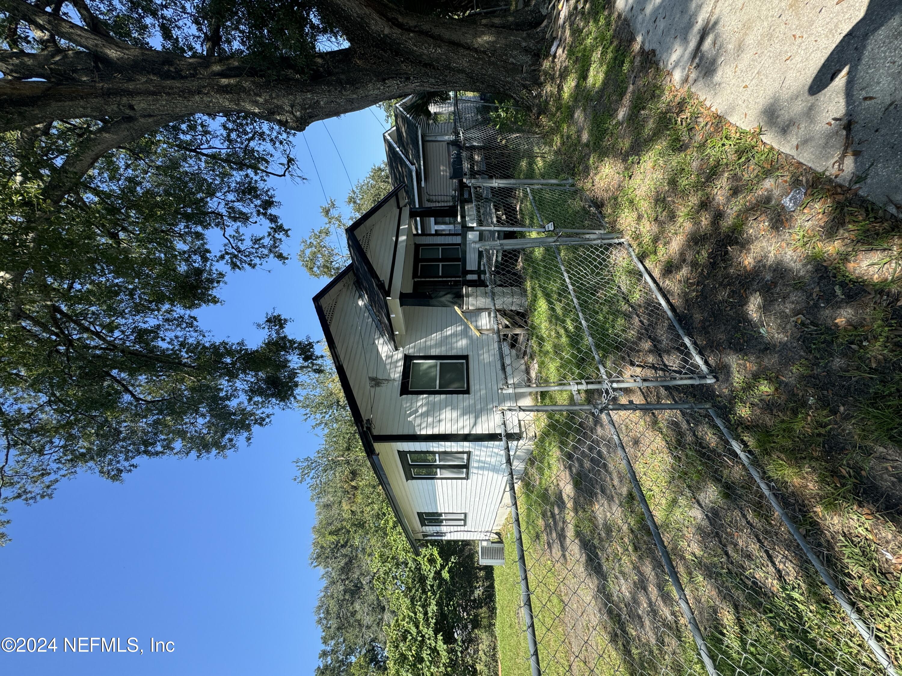 a view of a house with backyard and a tree