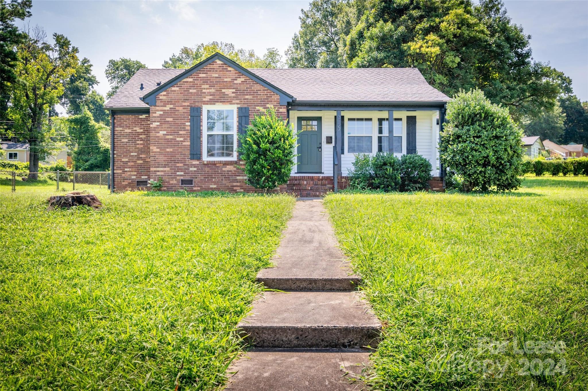 a front view of a house with a yard and garden