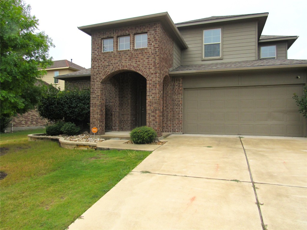 a view of a house with a yard and a garage