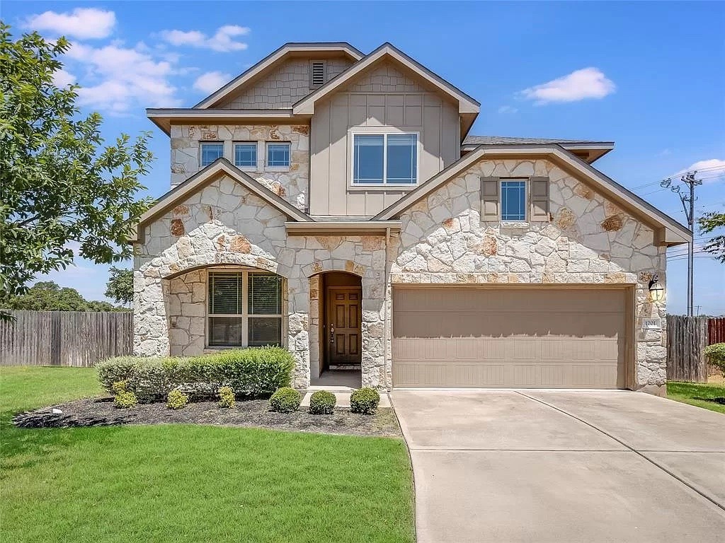 a front view of a house with a yard and garage