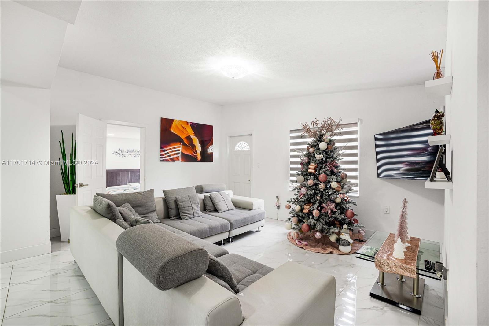 a living room with furniture and a potted plant