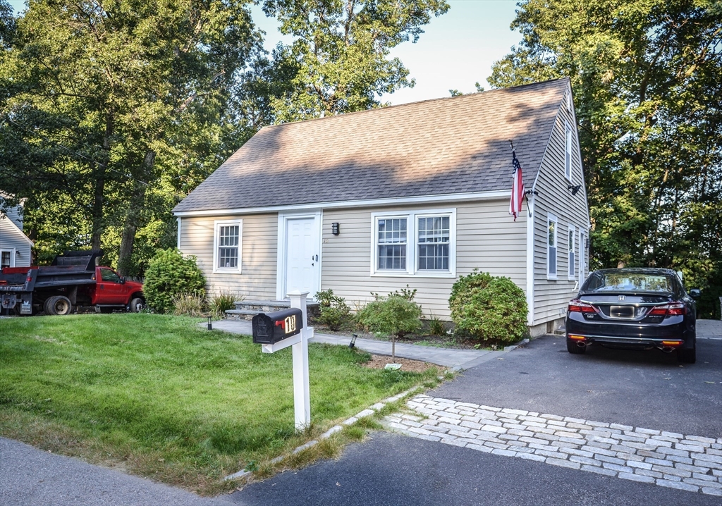 a front view of a house with a yard and trees