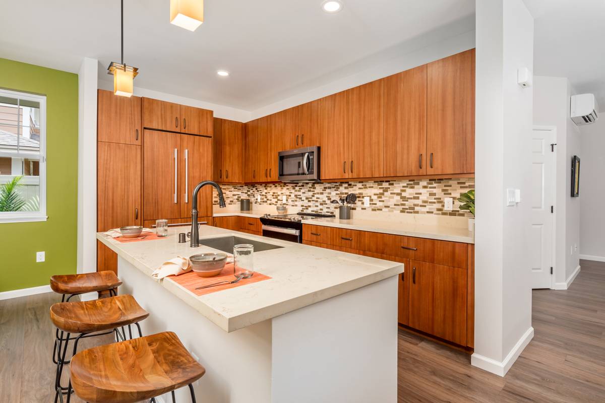 a kitchen with stainless steel appliances kitchen island granite countertop a table chairs and a refrigerator