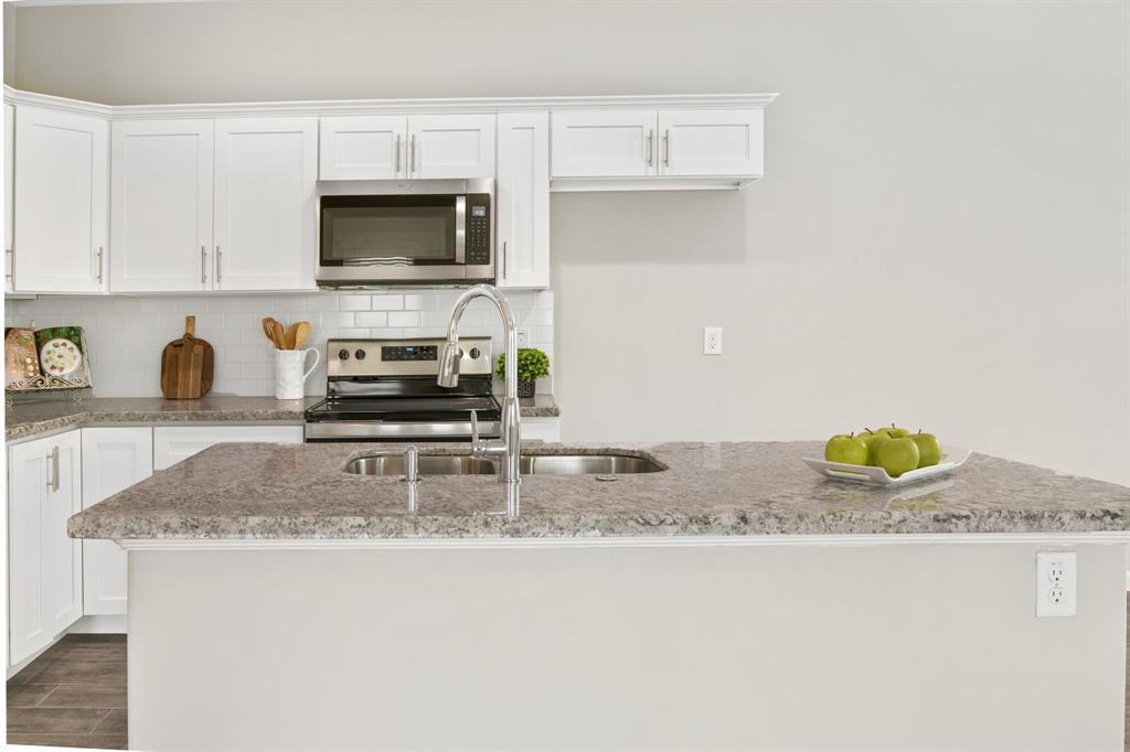 a kitchen with granite countertop a sink a stove and a granite counter tops