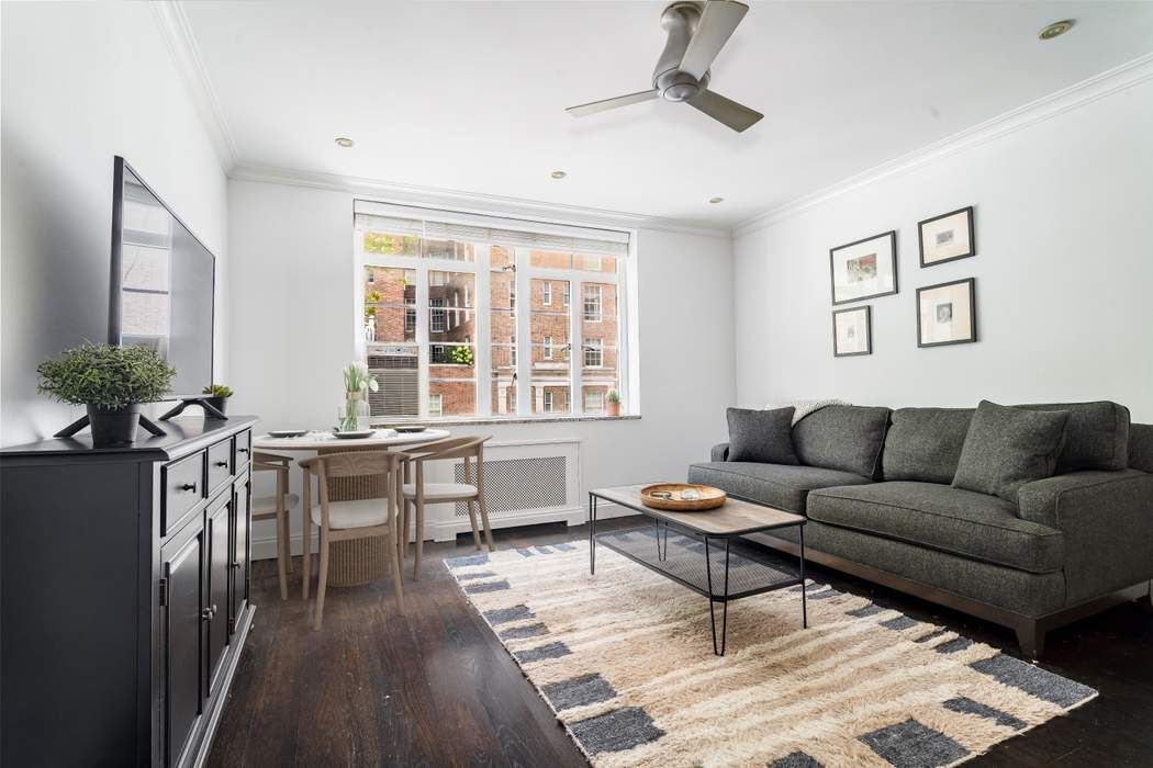 a living room with furniture a wooden floor and a window