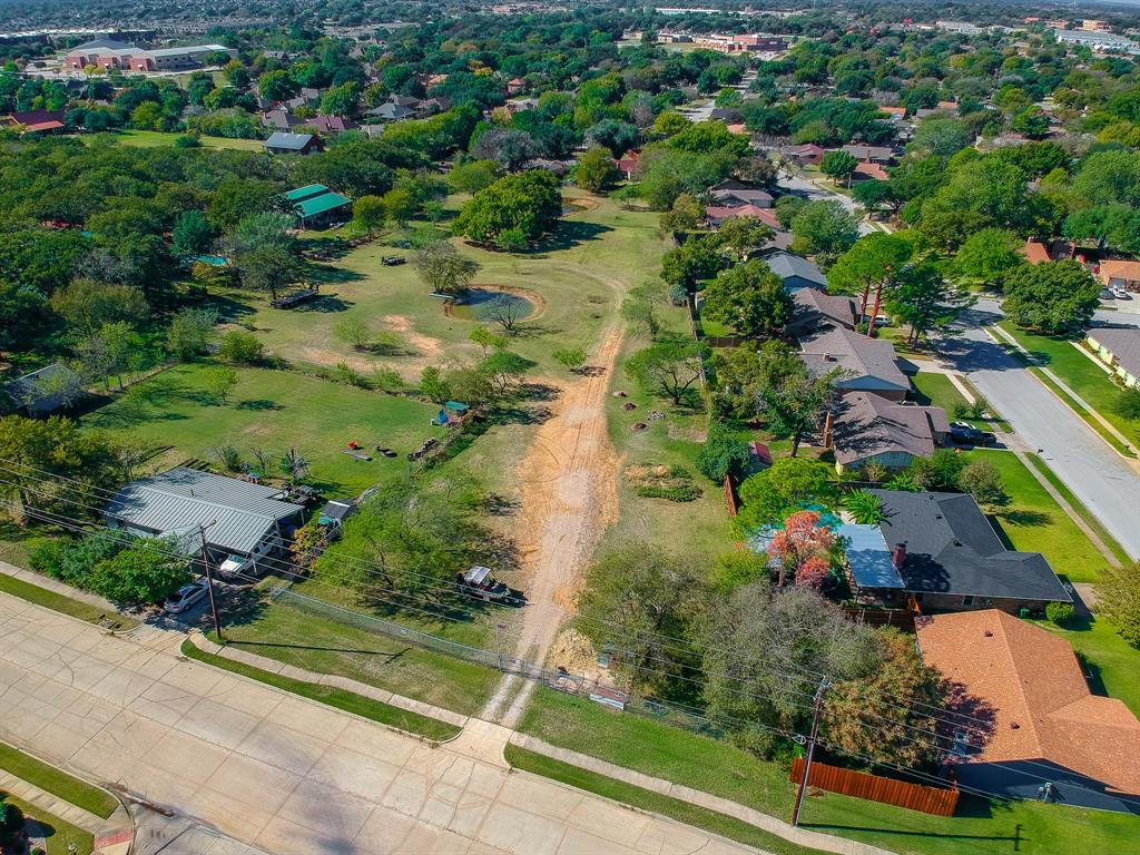 an aerial view of residential house with outdoor space and trees all around