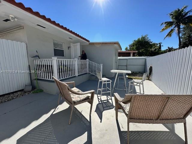 a roof deck with table and chairs and potted plants with wooden floor