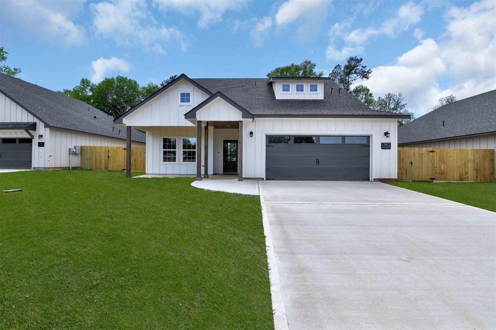 a view of a house with a yard and large tree