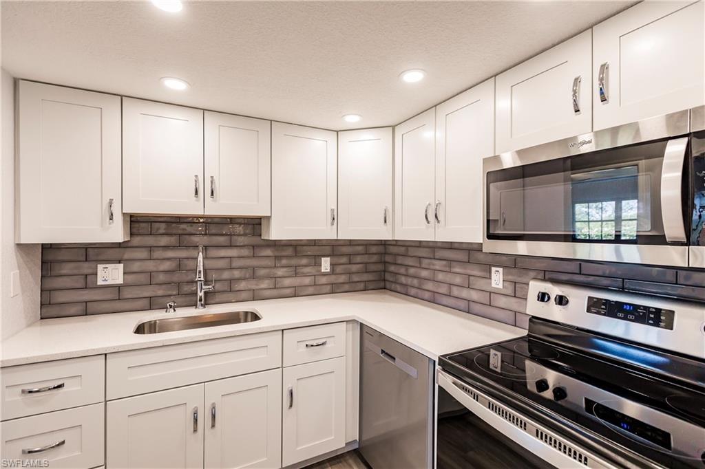 a kitchen with sink a microwave and cabinets