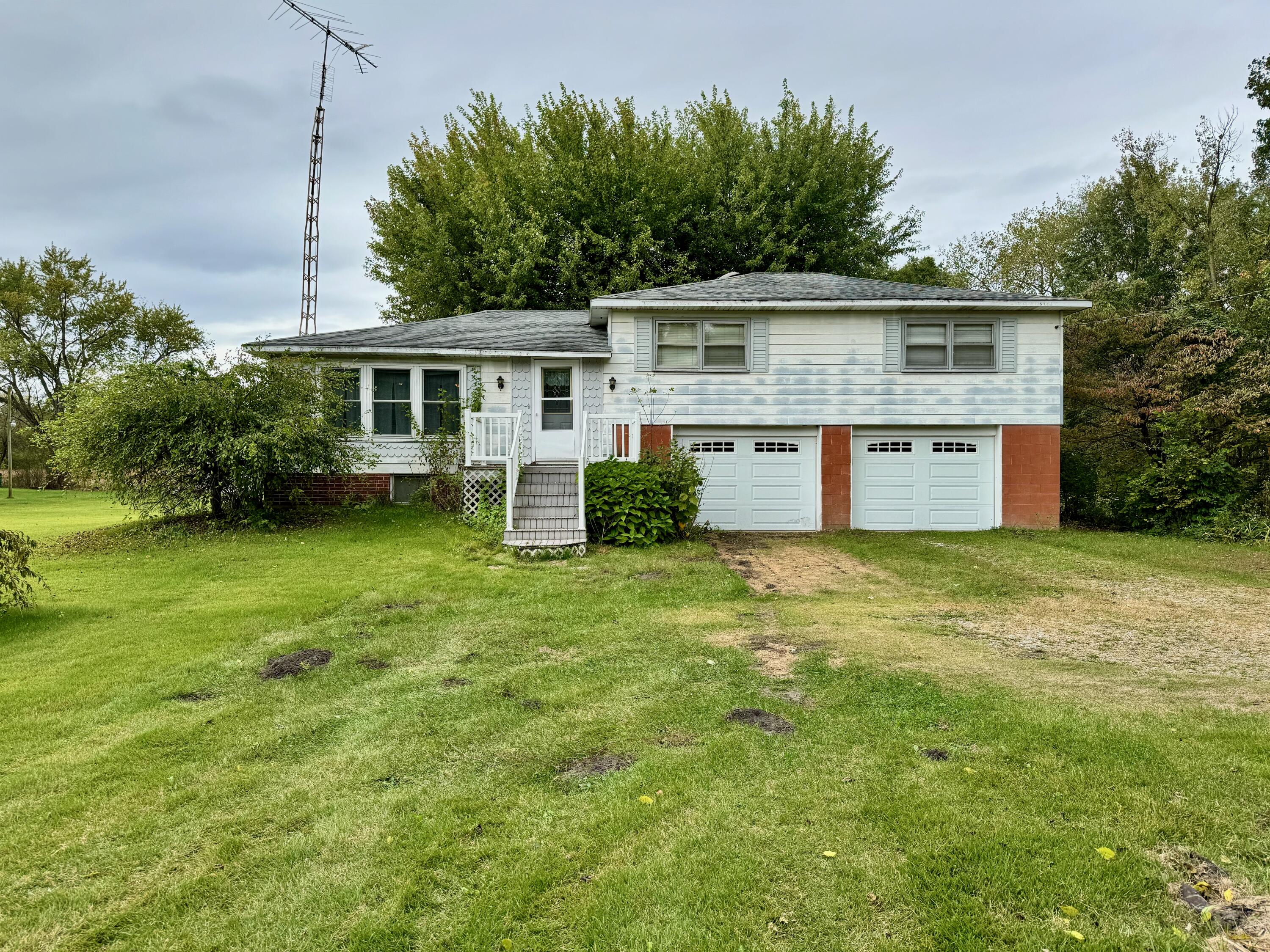 a front view of house with yard and trees in the background