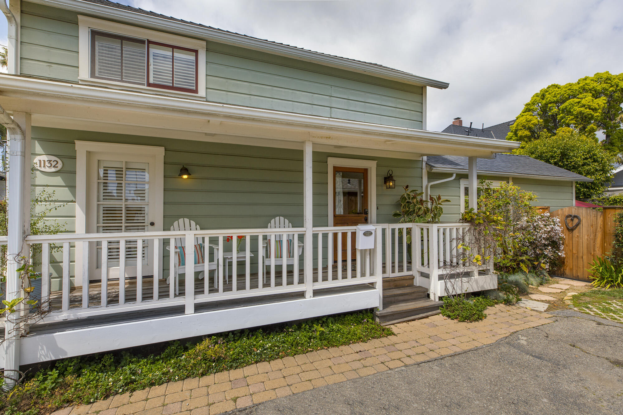 a view of a house with a small yard and wooden fence