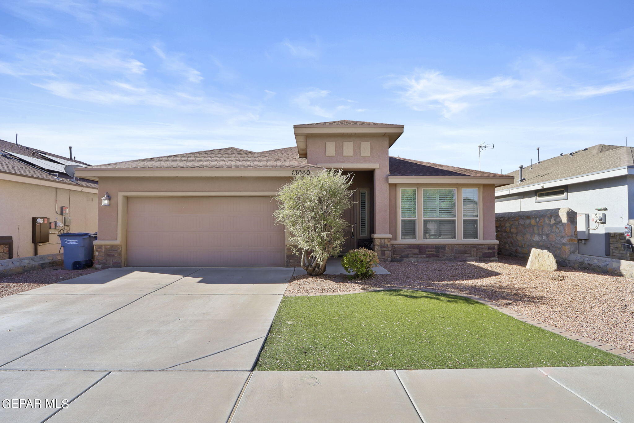 a front view of a house with a garden and yard