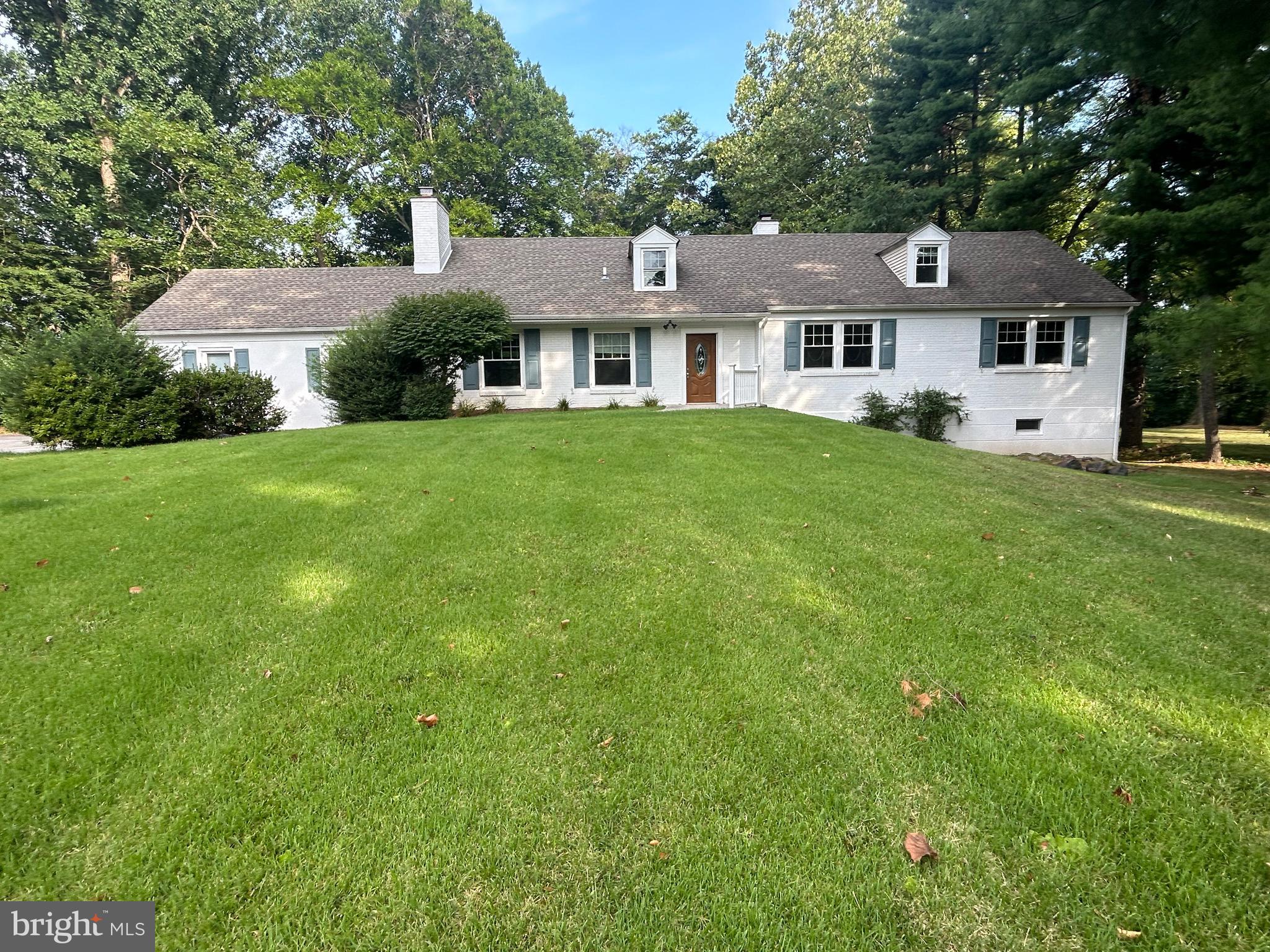 a front view of a house with a yard and trees