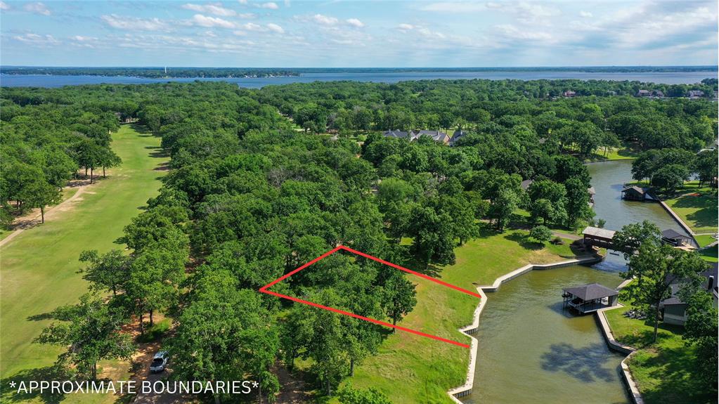 an aerial view of a house with a yard and lake view