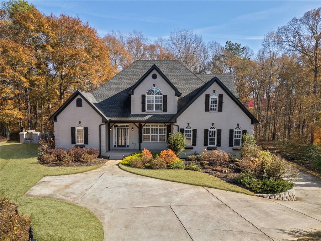 a front view of house with yard and trees around