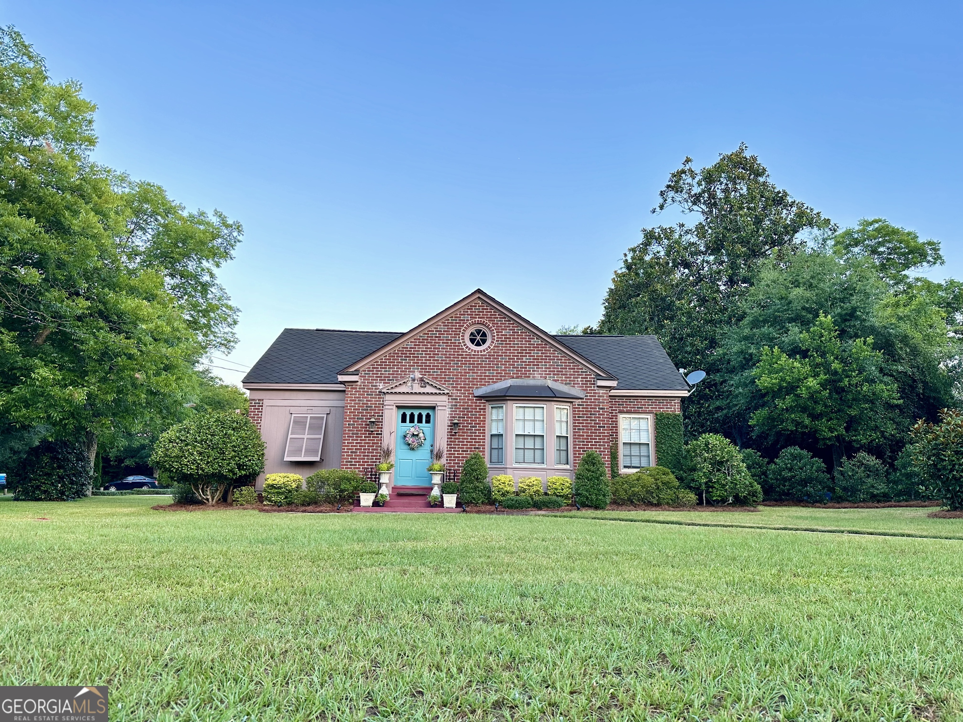 a front view of a house with a yard and trees