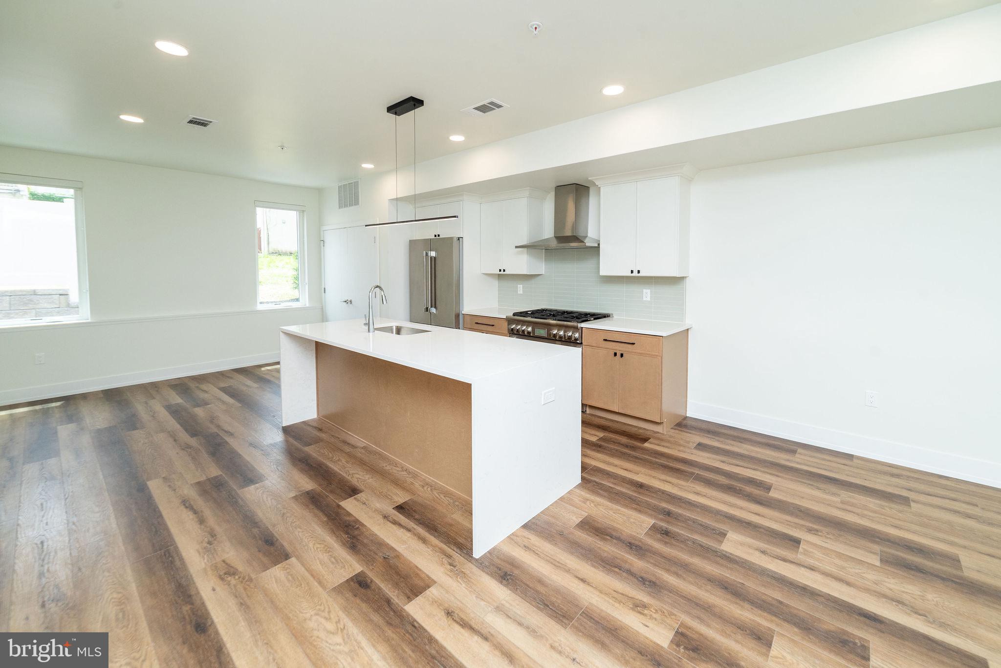 a kitchen with stainless steel appliances granite countertop a stove a sink and a refrigerator