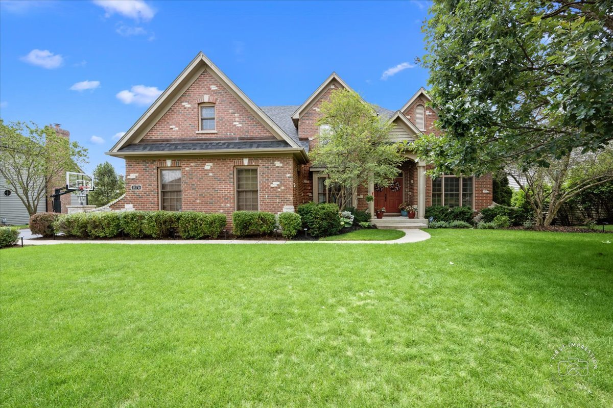 a front view of a house with a yard and trees