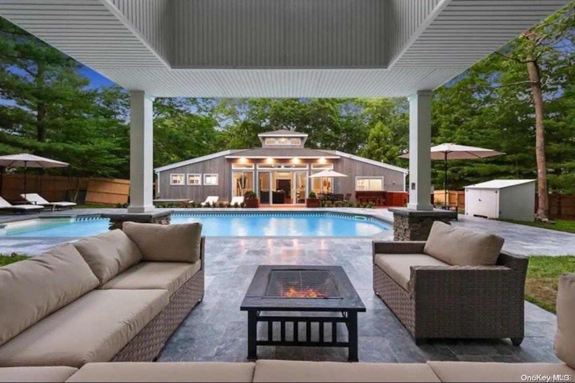 a view of a patio with couches and a table and chairs with wooden floor fence and balcony