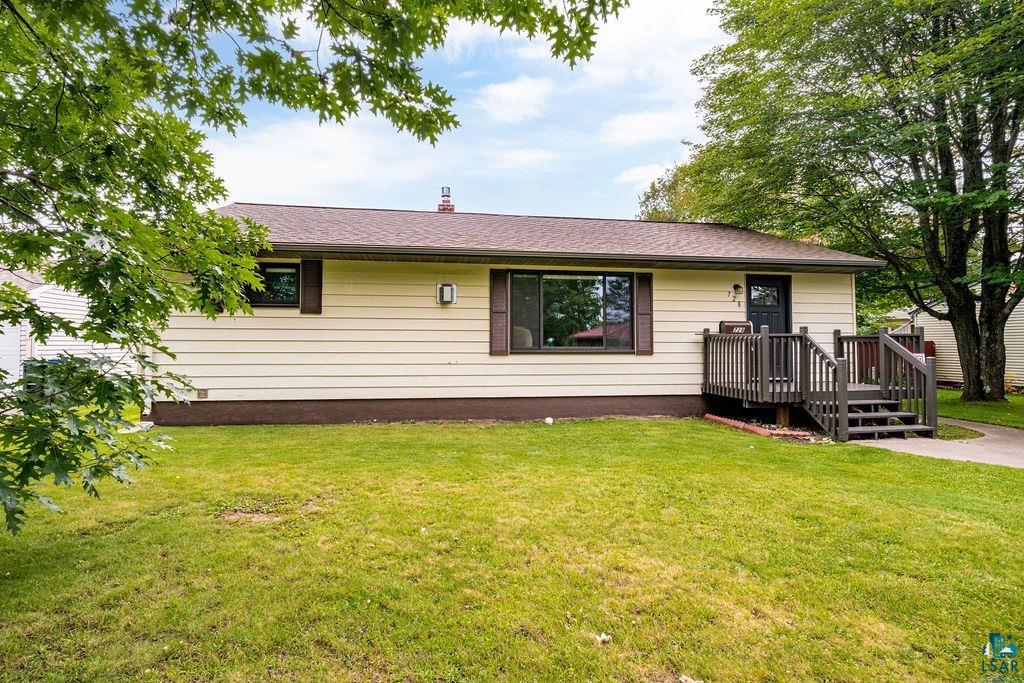 Back of house featuring a deck and a yard