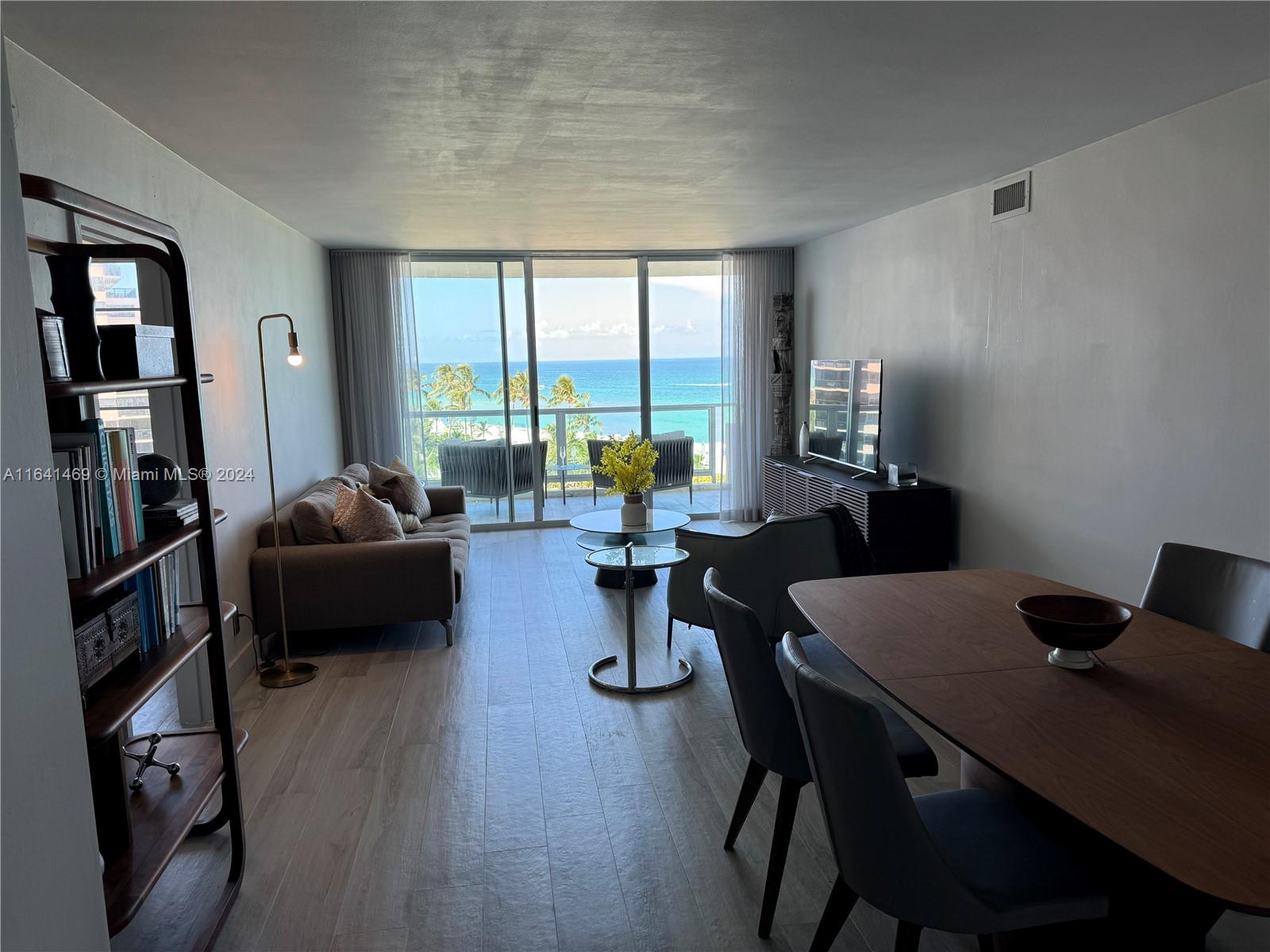 a living room with furniture and a floor to ceiling window