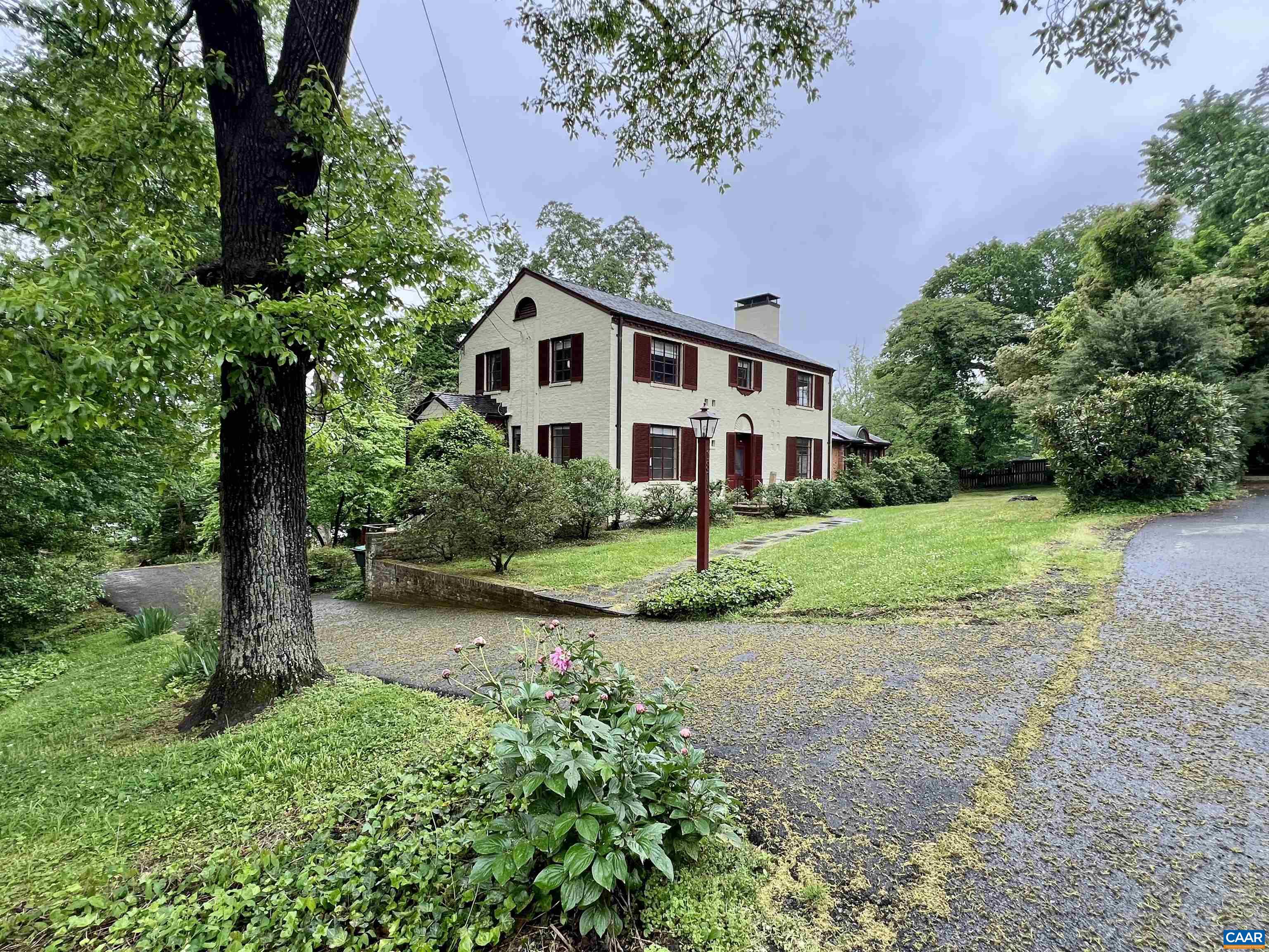 a front view of a house with a yard and trees