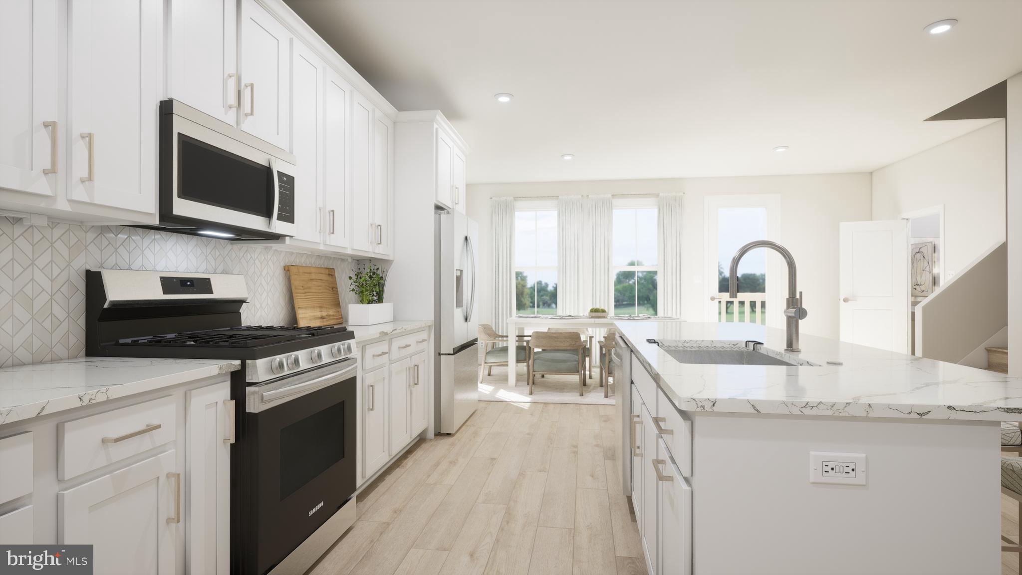 a kitchen with stainless steel appliances granite countertop a sink stove microwave and refrigerator