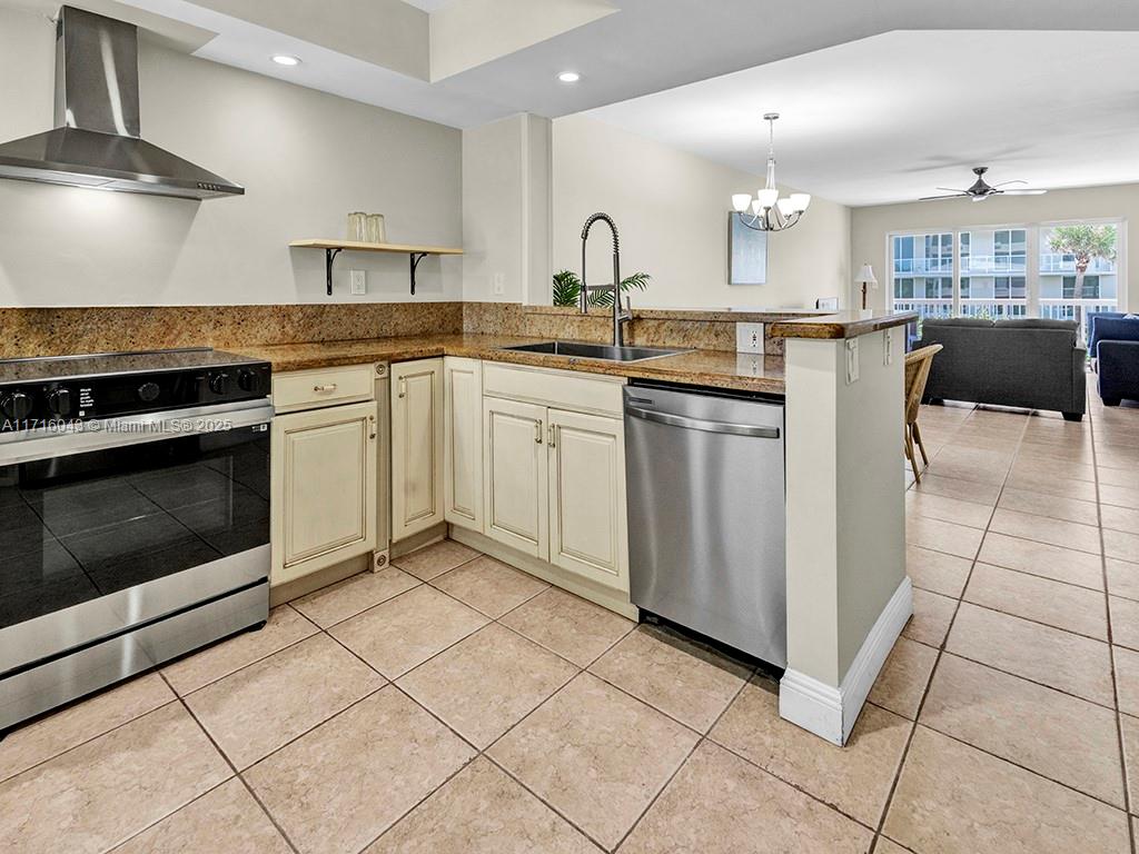 a kitchen with stainless steel appliances granite countertop a stove a sink and a microwave