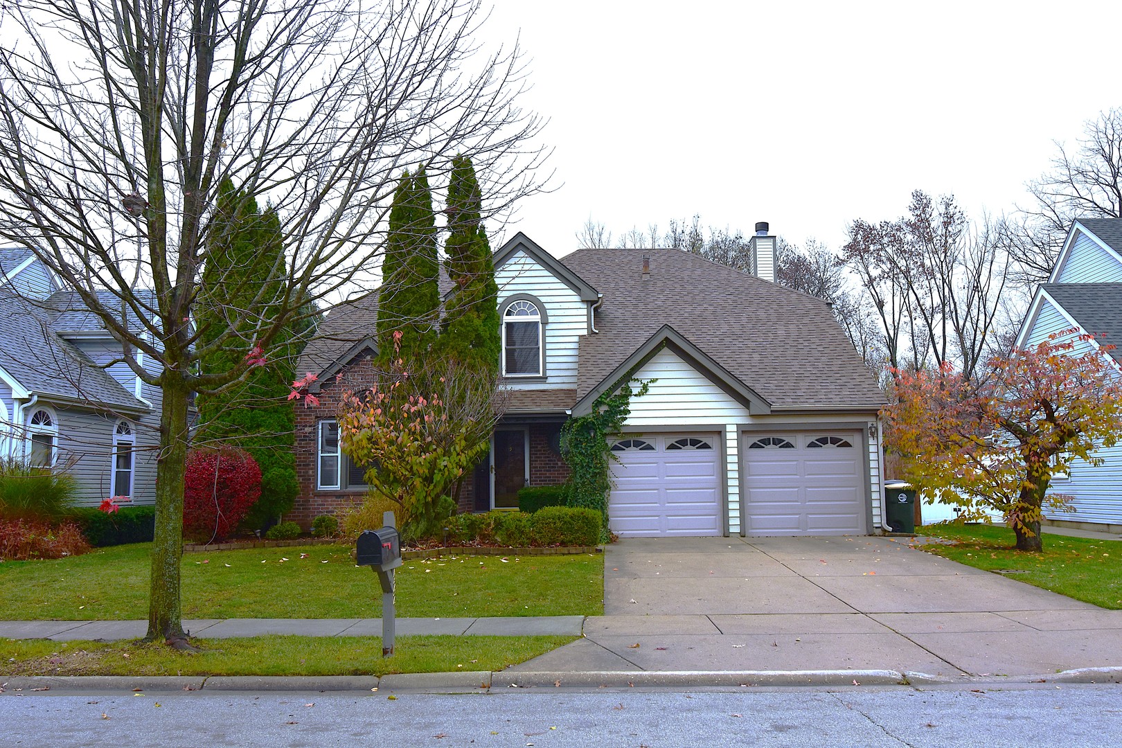 a front view of a house with a yard and trees