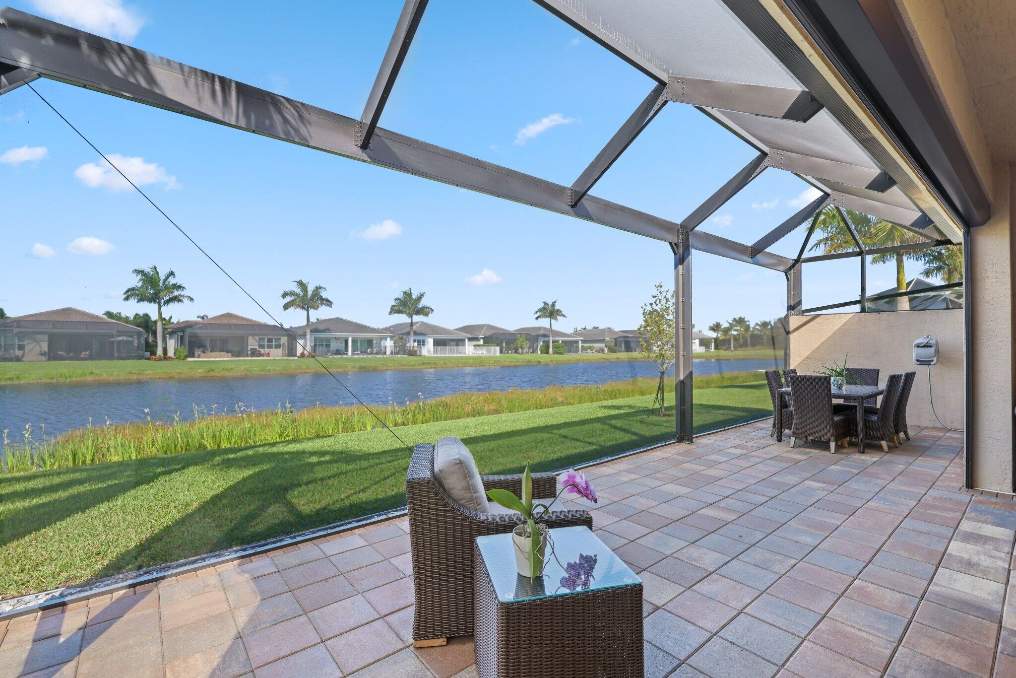 a view of a swimming pool and lounge chairs in back yard of the house