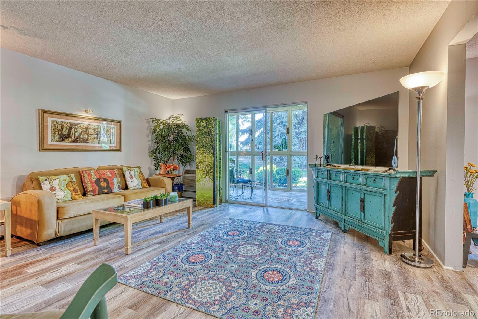 a living room with furniture a flat screen tv and a floor to ceiling window