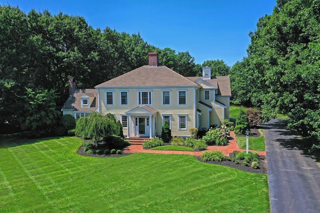 a front view of a house with a garden and trees