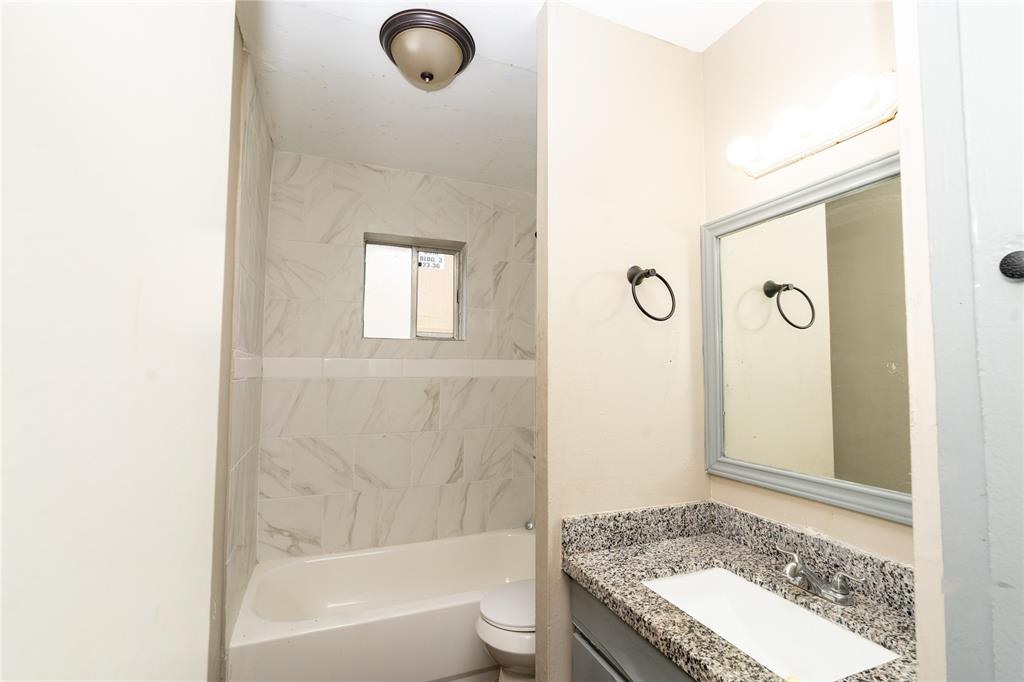 a bathroom with a granite countertop bathtub shower and a sink