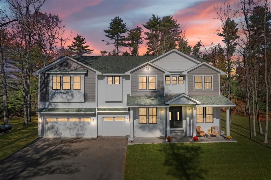 View of front of house with a garage and a lawn