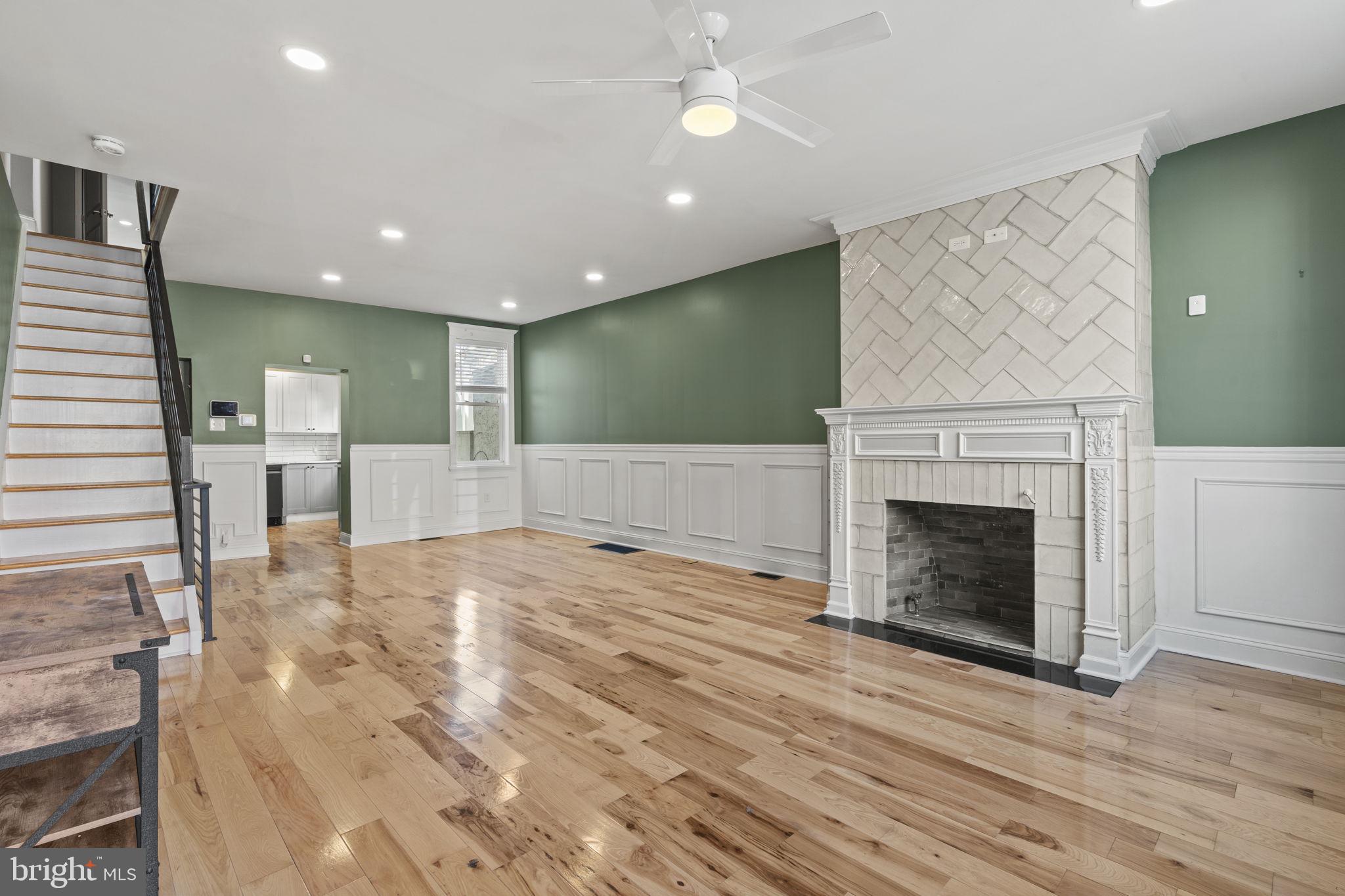 an empty room with wooden floor and fireplace