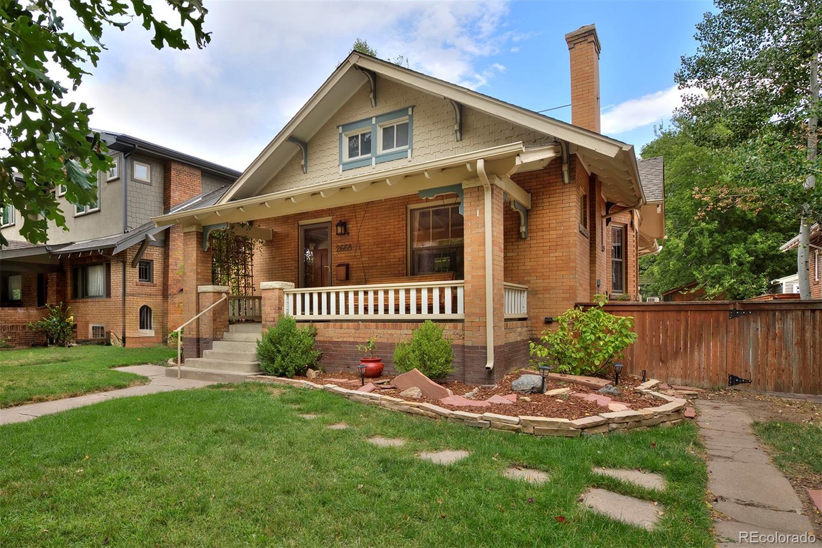 a front view of a house with a yard and fence