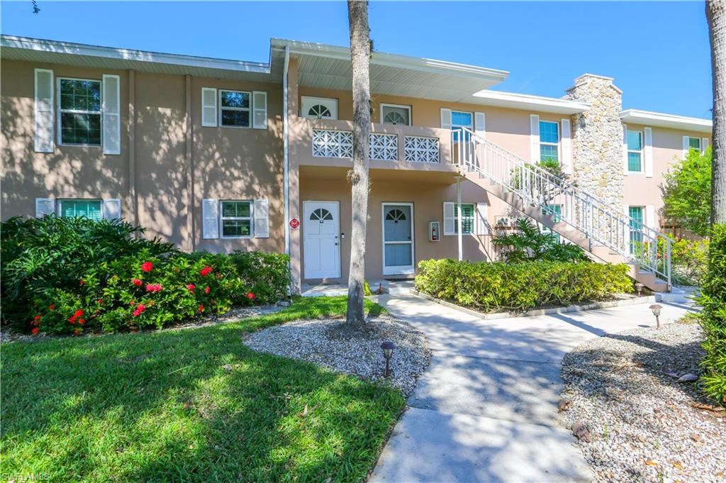 Townhome / multi-family property featuring a balcony and a front lawn