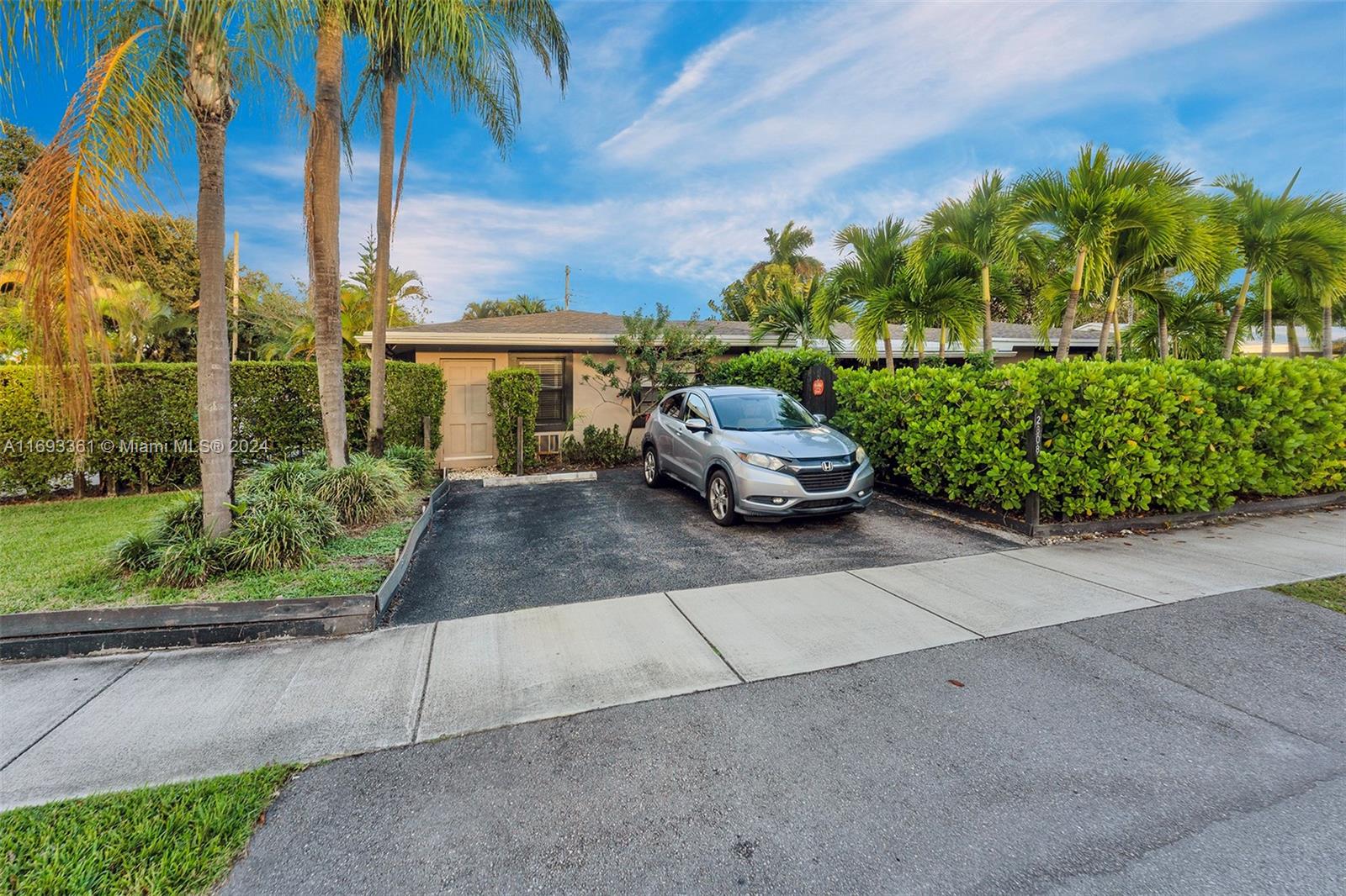 a car parked in front of a house with a garden