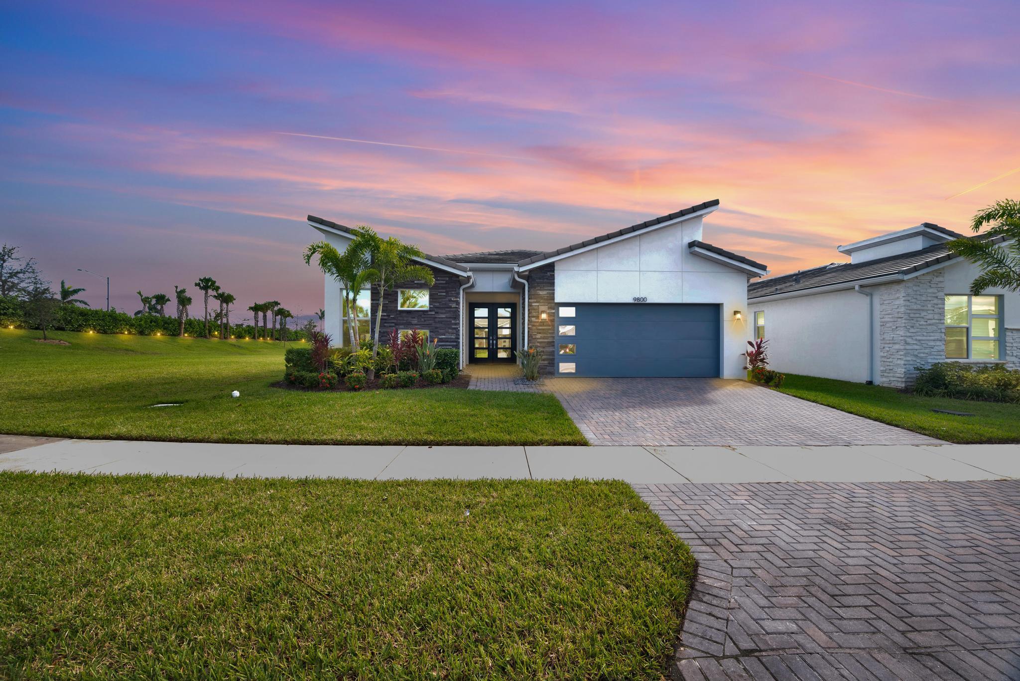 a front view of a house with a yard and garage