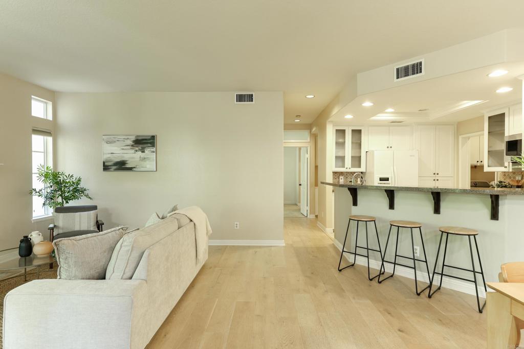 a living room with furniture and a dining table with kitchen view