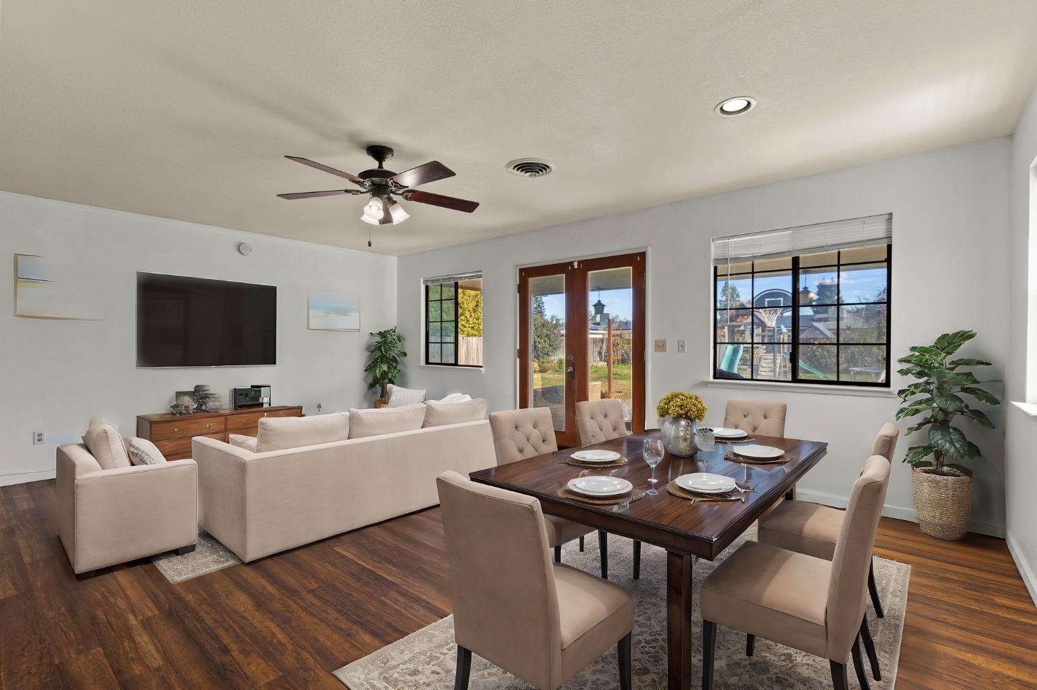 a living room with furniture a flat screen tv and a large window