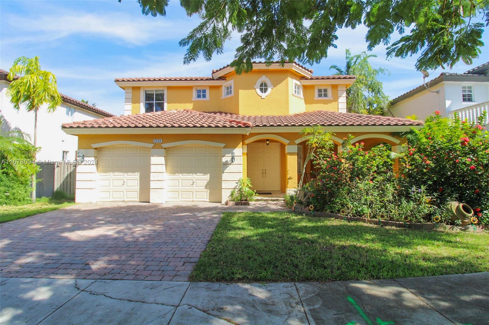 a front view of a house with a garden and yard