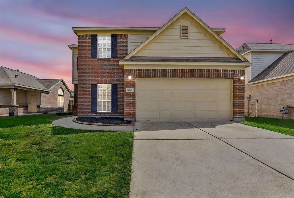 a front view of a house with a yard and garage